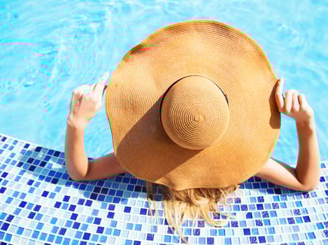 Woman in a hat enjoying a swimming pool photo