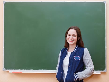 Student girl standing near blackboard, schooler photo