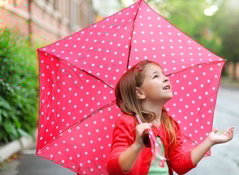 Little girl with polka dots umbrella under the rain photo
