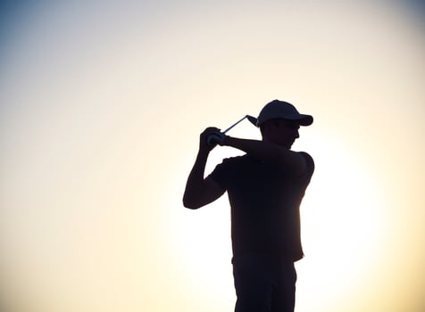 Male golfer at sunset photo