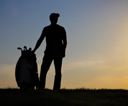 Male golfer at sunset photo