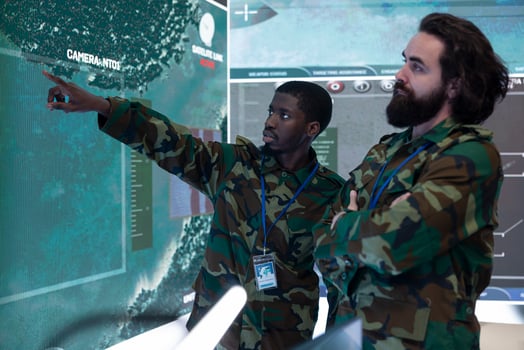 Team of recruits examining new surveillance footage on a big screen, gathering intelligence from satellite radar system in military monitoring room. GPS tracking on a world map, navy division. photo