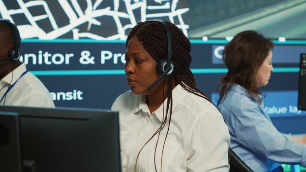 Diverse employees at call center transmitting gps coordinates of routes without traffic to help with express order delivery. Operators following surveillance footage on radar system and map. Camera A. photo