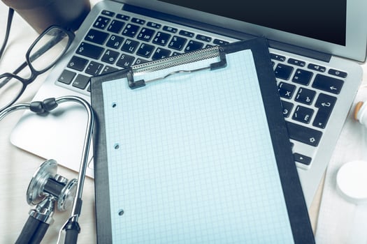 Stethoscope on laptop, close-up photo
