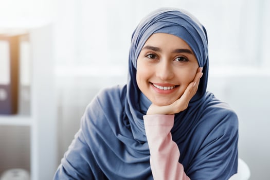 Closeup portrait of beautiful arabic businesswoman in hijab sitting in office and posing to camera, selective focus, empty space photo
