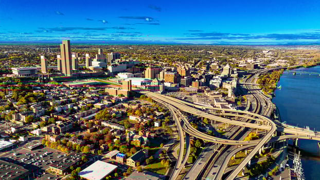 Albany aerial cityscape view. The vibrant city of Albany, showcases its skyline and bustling highways against a clear blue sky on a sunny day. photo