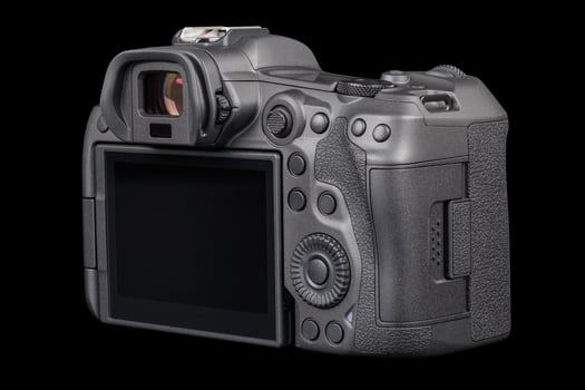 black professional mirrorless camera body isolated on black background photo