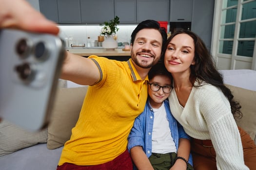 Family bonding time captured in a cozy living room while taking selfies photo