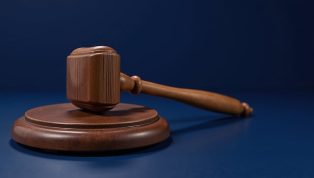 Wooden gavel resting on a blue table against a dark blue backdrop symbolizes law justice and legal matters photo