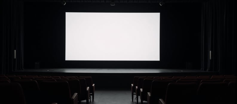 A staged venue featuring rows of empty seats and a large blank screen photo