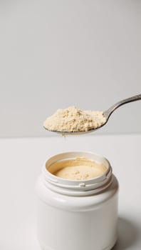 Scooping protein powder with an opentopped spoon photo