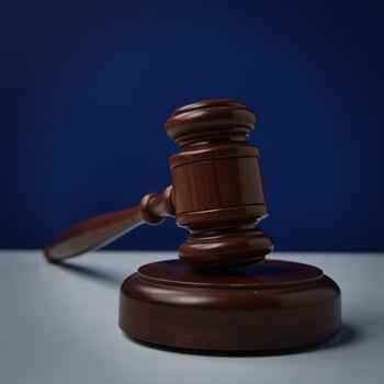 Wooden gavel resting on a blue table against a dark blue backdrop symbolizes law justice and legal matters photo