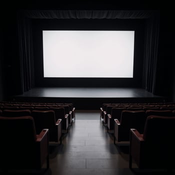 A staged venue featuring rows of empty seats and a large blank screen photo