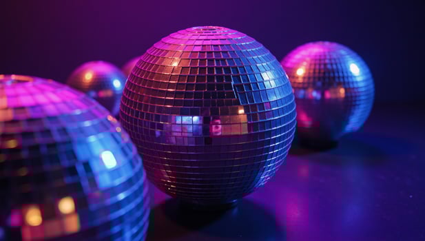A lively disco scene featuring disco balls under vibrant purple and blue lighting at night photo