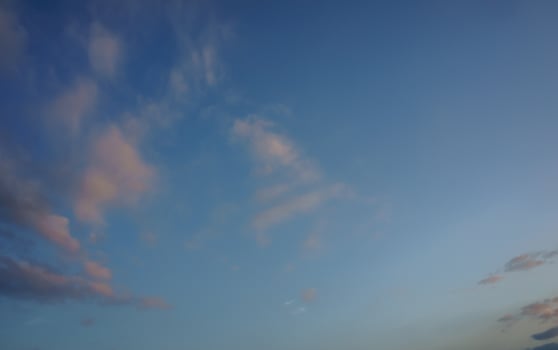 A tranquil evening sky filled with soft clouds above a serene landscape at dusk photo