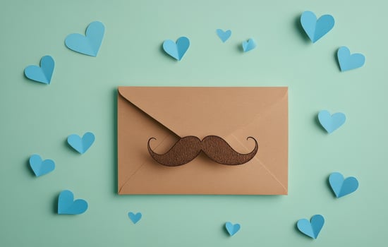 Blue envelope with mustache design surrounded by heart shapes in a creative arrangement photo