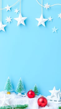 white paper stars snowflakes adorn a blue background with miniature holiday decorations photo