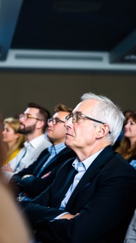 attentive audience members looking upward during a professional meeting photo