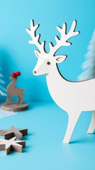 white wooden reindeer figurine on blue background photo
