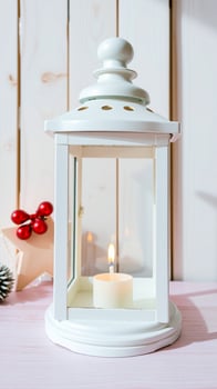 white lantern with a lit candle on a pink wooden surface photo
