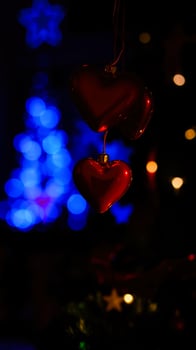 red heart ornaments hanging against a background blue yellow lights photo