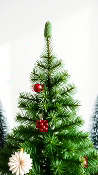 small artificial pine tree with red white ornaments photo
