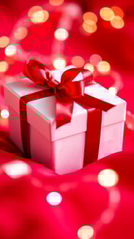 white gift box with a red ribbon on a red background photo