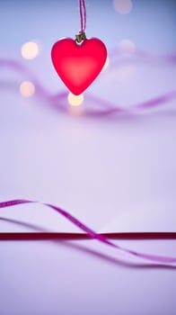 red heart ornament hanging on a purple background photo