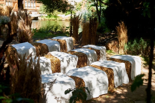 Wedding decoration. Floristics. Sheaves of hay in squares, for sitting. Covered with a white cloth. Guest area. photo