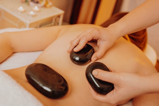 Woman making massages by lava stones in a beauty saloon, lifestyle and healthcare concept photo