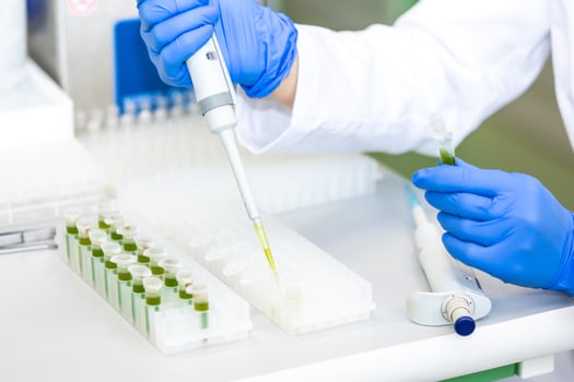 Scientist with dropper dripping liquid into a test tube in scientific laboratory, concept of pharmaceutical environment photo