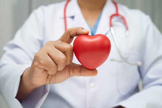Asian woman doctor holding red heart for health in hospital. photo