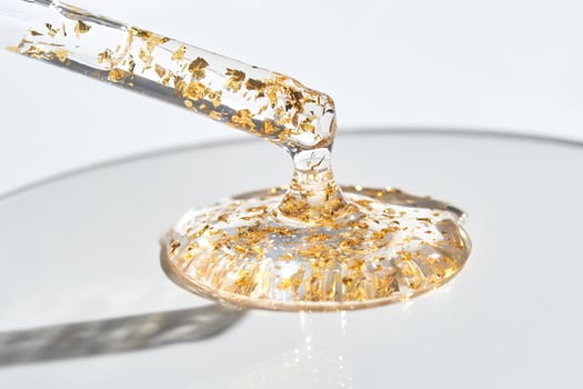 Luxurious translucent serum with gold flakes in dropper for premium skincare and beauty treatments photo