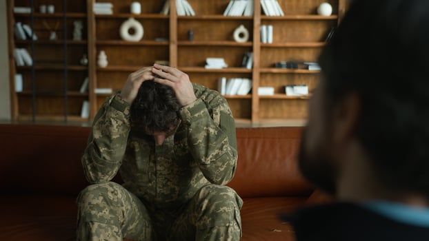 Worried depressed frustrated Caucasian sad despair patient man male client guy military combat uniform army soldier officer holding head pain talking to psychologist war stress crisis office therapy photo