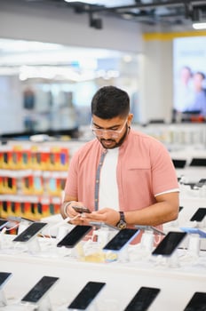 handsome young man buying new mobile in the electronic shop. photo