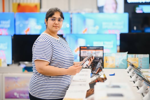 Smart modern female customer choosing coffee machine at electronics store photo