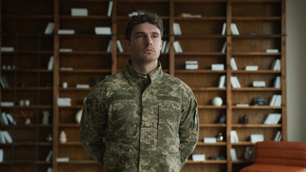 Calm confident Caucasian serious man male guy in military combat uniform army soldier serving in armed forces veteran warrior officer posing with hands behind back looking distance at home office room photo
