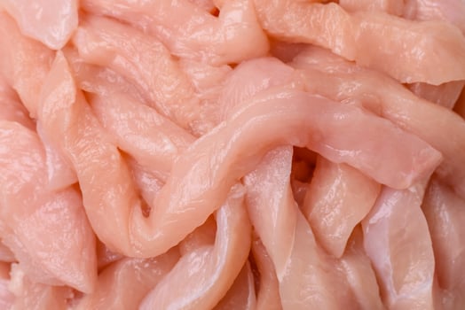 Raw chicken fillet cut into strips with spices and herbs photo