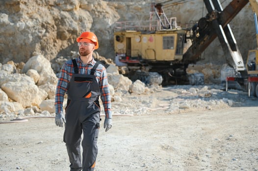 Extraction of stone. Male worker next to stone quarry. Engineer at construction site photo