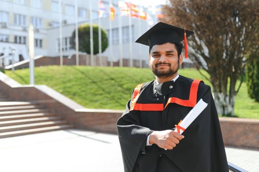 Handsome indian graduate in graduation glow with diploma photo