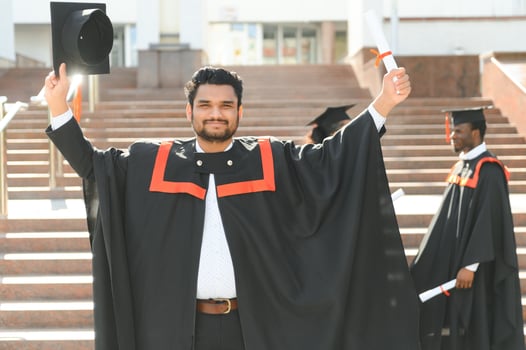 Handsome indian graduate in graduation glow with diploma photo