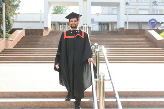 Portrait of happy man, graduation or student in university campus photo