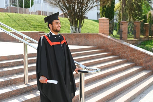 Handsome indian graduate in graduation glow with diploma photo