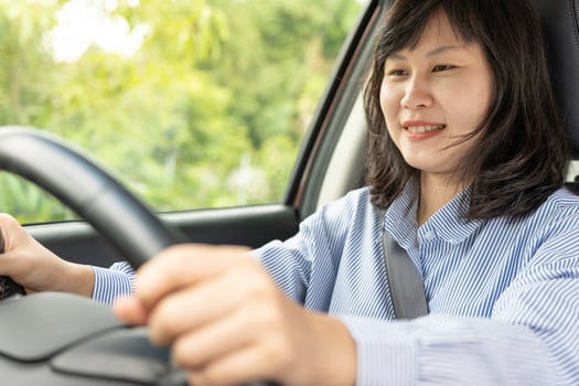 Woman use seatbelt and drives with intent, safe driving, driving practice, cheerful woman sits comfortably in the driver's seat with her hand confidently , readiness for a journey photo