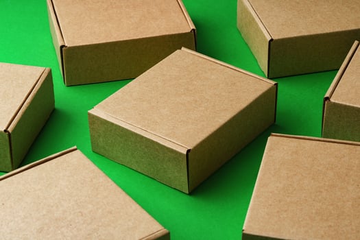 Brown cardboard boxes arranged on a vibrant green surface photo