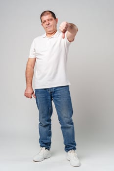 A middle-aged man expressing disapproval with a thumbs-down gesture i photo