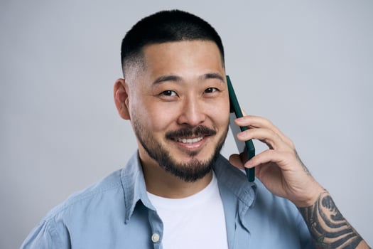 Asian man smiling while talking on the phone photo