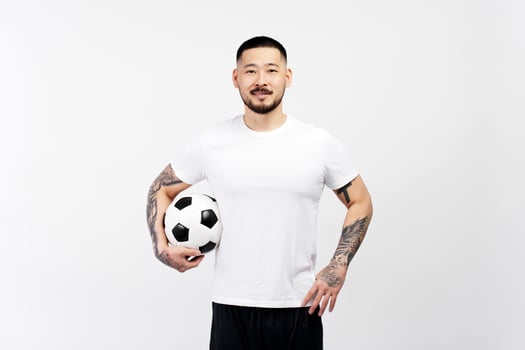 Football player posing with soccer ball on white background photo