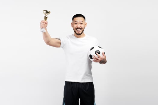Young soccer player holding trophy and soccer ball celebrating victory photo