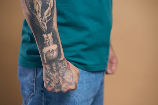 Man showing tattooed arm and clenched fist photo